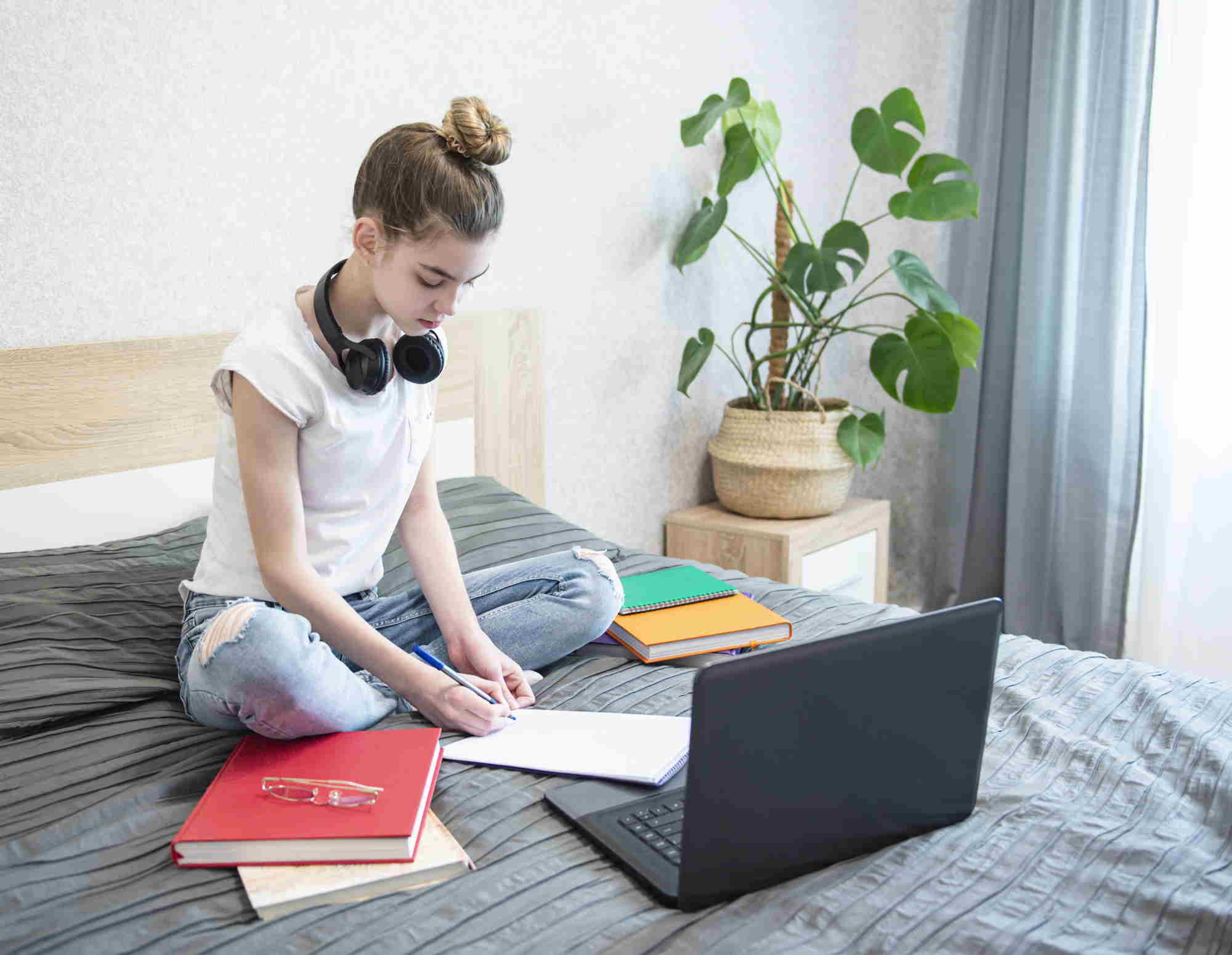 adolescente estudiando Chica adolescente estudiando en la cama para aprender idiomas