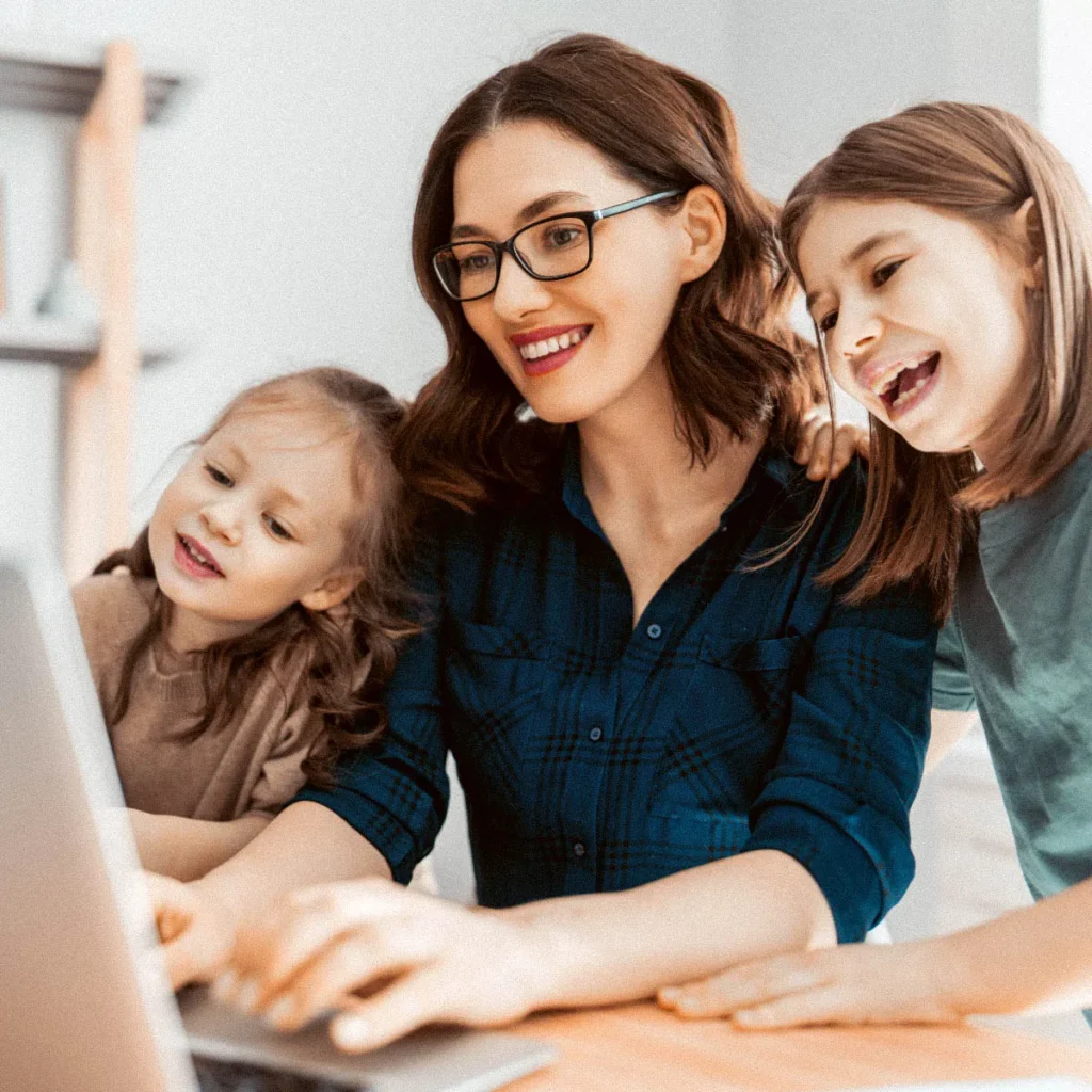 Madre con sus dos hijas conectando a una clase online para que aprendan alemán