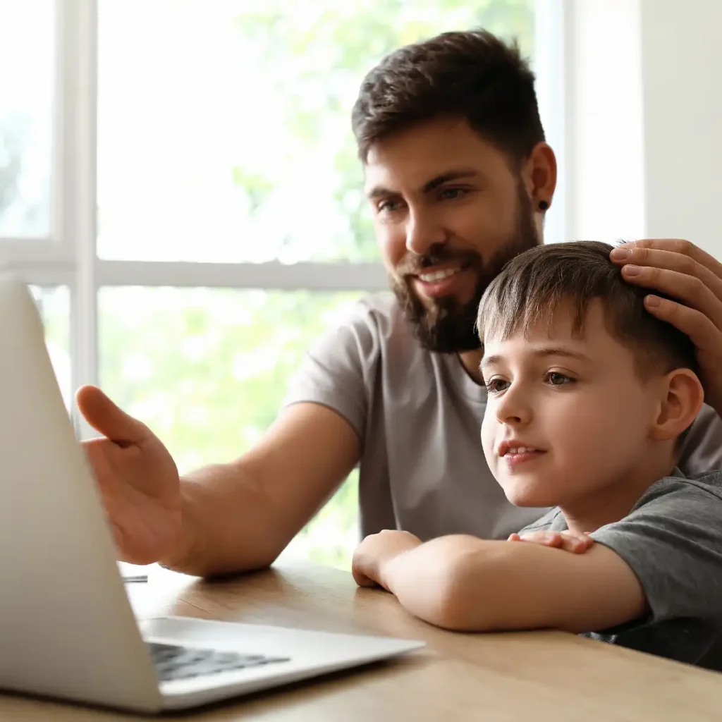 Niño disfrutando con su padre de clase de Español online por videoconferencia