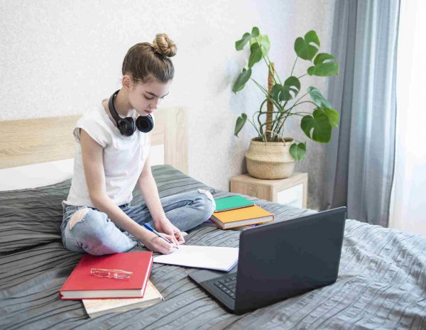 adolescente estudiando Chica adolescente estudiando en la cama para aprender idiomas